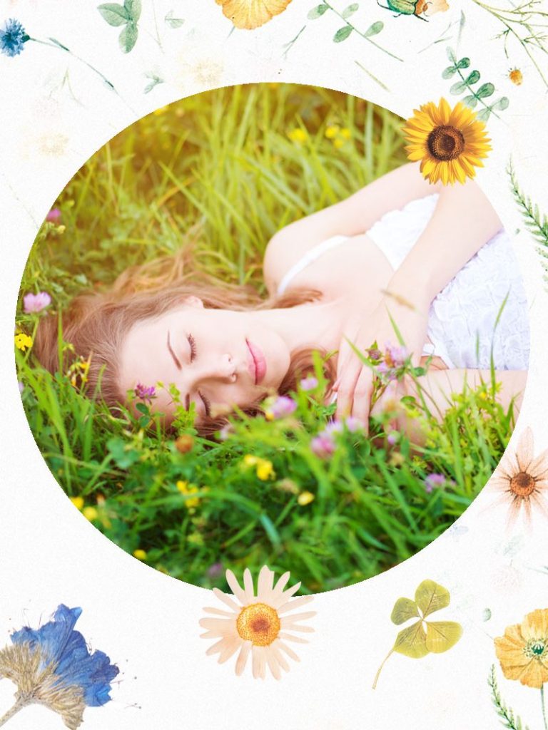 Frau liegt entspannt auf einer blühenden Wiese, umgeben von Blumen und Sonnenlicht.
